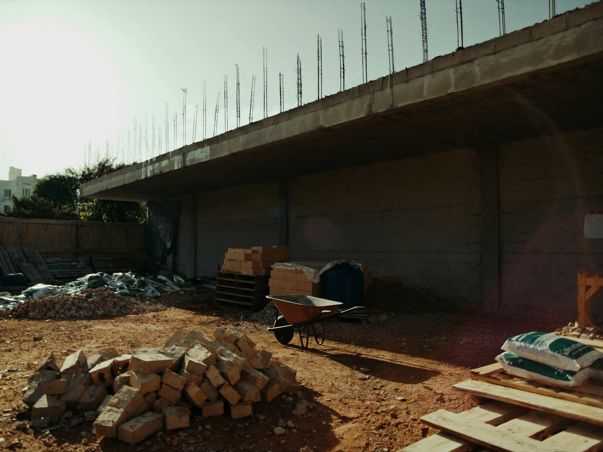 Obra pública parada, com material empilhado e ninguém trabalhando